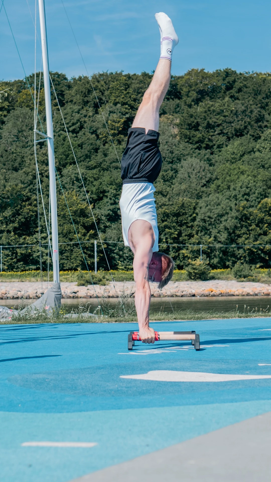 Mattias træner kropskontrol med håndstand på parallettes